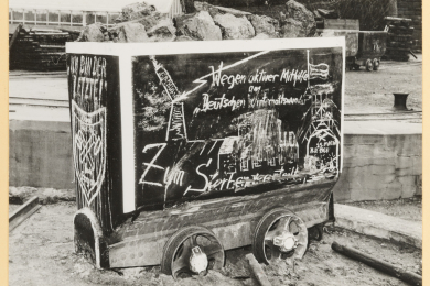 Abbildung einer Schachtanlage auf der Seitenwand eines Förderwagens. 