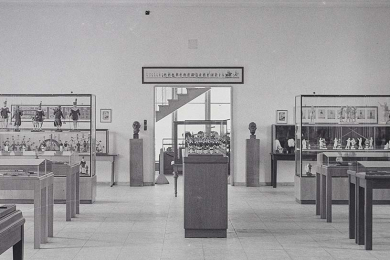 Ausschnitt aus einem schwarz-weiß-Foto einer Ausstellungshalle, in deren Zentrum die Bergparade unter einer Glashaube steht.
