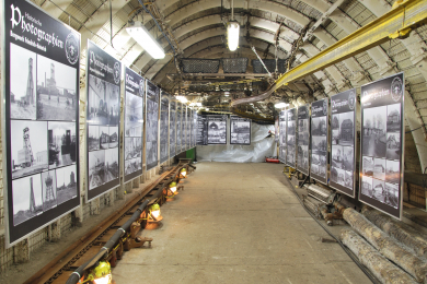 Blick in den Lehrstollen des Museums mit einer Fotoausstellung an den Seitenwaenden