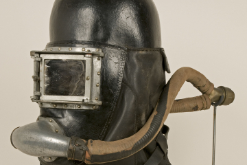 Helm aus dickem, schwarzen Leder mit zweiflügigem Sichtfenster und Atemmundstück