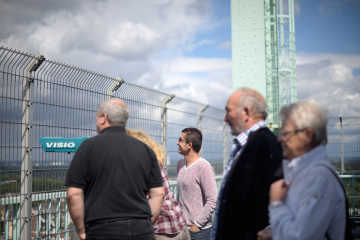 Männer und Frauen blicken in die Ferne auf der Aussichtsplattform des Fördergerüstes über dem Deutschen Bergbau-Museum Bochum