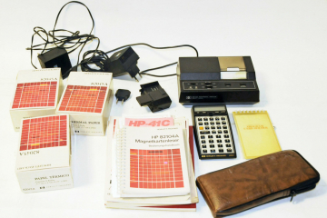 Taschenrechner aus schwarzem Kunststoff mit Hülle, Netzteilen, Handbüchern, Magnetkartenleser, Thermodrucker und Thermodruck-Papier