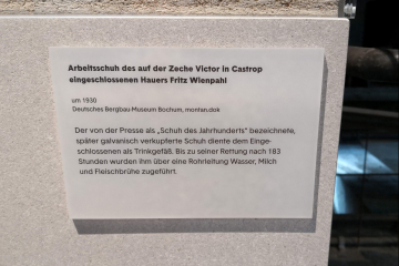 Knappe Beschreibung des Schuhs an der Vitrine in der Ausstellung „Das Zeitalter der Kohle“