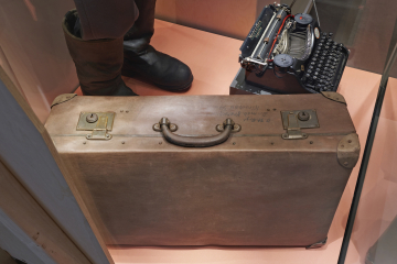 Ein Koffer, eine Schreibmaschine und zwei Stiefel in einer Vitrine im Deutschen Bergbau-Museum Bochum