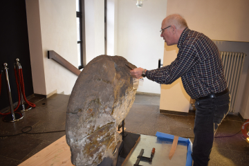 Ein Mann nimmt Proben von dem Riesenammoniten im Deutschen Bergbau-Museum Bochum 