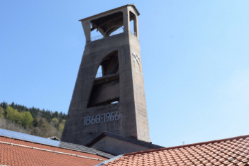Ein Fördergerüst aus Beton erhebt sich über einigen Gebäuden